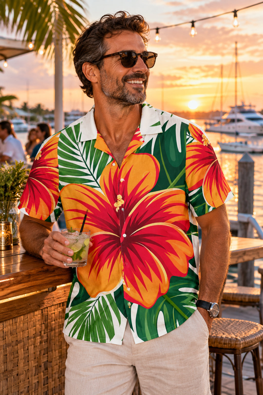 A short-sleeve button-up Hawaiian shirt with a bold tropical print featuring large red and orange hibiscus flowers and green palm leaves on a white base.